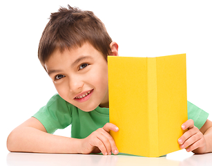 Image showing Little boy plays with book