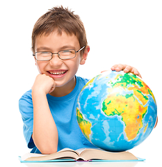 Image showing Little boy is examining globe