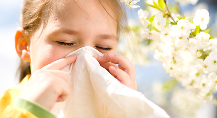 Image showing Little girl is blowing her nose