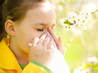 Image showing Little girl is blowing her nose