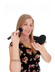 Image showing Beautiful woman putting on makeup