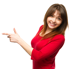 Image showing Portrait of a young woman pointing to the left