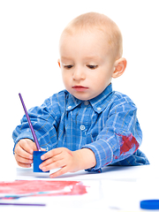 Image showing Little boy is playing with paints