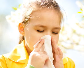 Image showing Little girl is blowing her nose