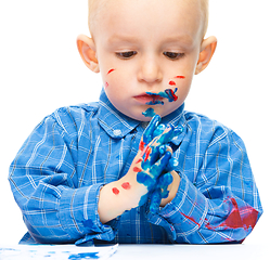 Image showing Little boy is playing with paints