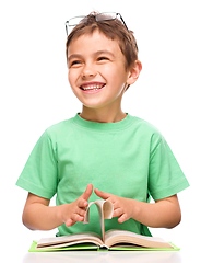 Image showing Little boy is reading a book