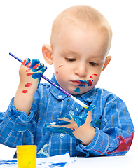 Image showing Little boy is playing with paints