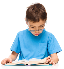 Image showing Little boy is reading a book