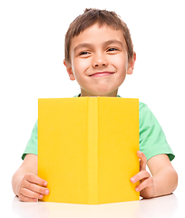 Image showing Little boy is reading a book