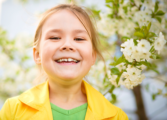 Image showing Portrait of a little girl near tree in bloom