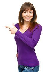 Image showing Portrait of a young woman pointing to the left