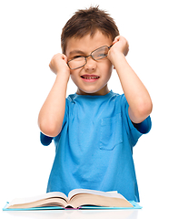 Image showing Little boy is reading a book