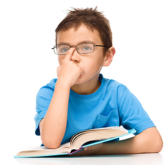 Image showing Little boy is reading a book