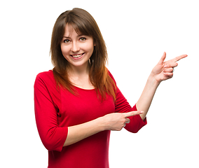 Image showing Portrait of a young woman pointing to the right