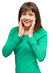 Image showing Woman is holding her face in astonishment