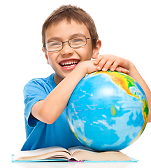 Image showing Little boy is examining globe