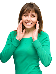 Image showing Woman is holding her face in astonishment