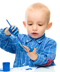 Image showing Little boy is playing with paints