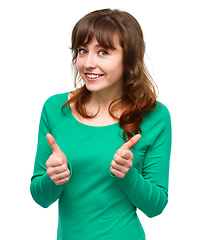 Image showing Woman is showing thumb up gesture