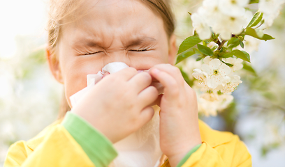 Image showing Little girl is blowing her nose