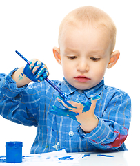 Image showing Little boy is playing with paints