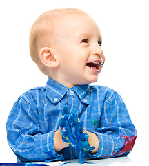 Image showing Little boy is playing with paints