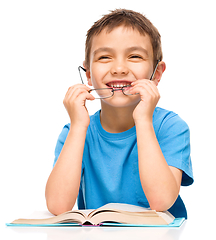 Image showing Little boy is reading a book