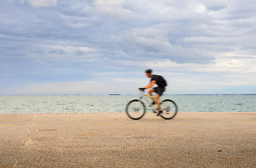 Image showing Man riding a bicycle waterfront