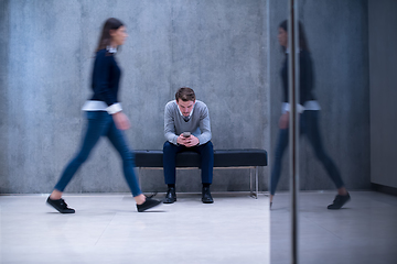 Image showing businessman using mobile phone while sitting on the bench