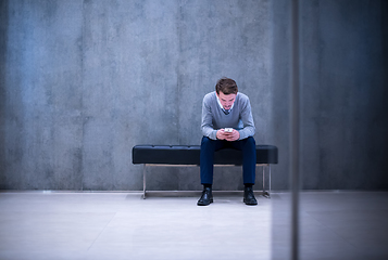 Image showing businessman using smart phone while sitting on the bench