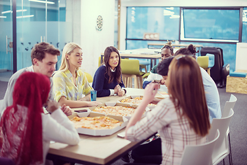 Image showing multiethnic business team eating pizza