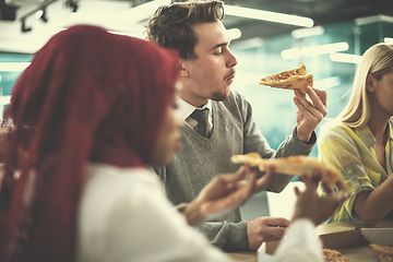 Image showing multiethnic business team eating pizza