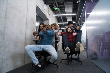 Image showing multiethnics business team racing on office chairs