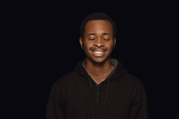 Image showing Close up portrait of young man isolated on black studio background