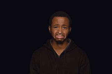 Image showing Close up portrait of young man isolated on black studio background