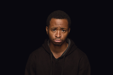 Image showing Close up portrait of young man isolated on black studio background