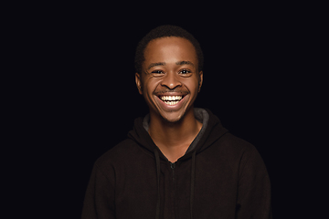 Image showing Close up portrait of young man isolated on black studio background