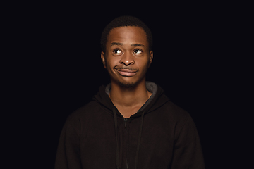 Image showing Close up portrait of young man isolated on black studio background