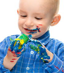 Image showing Little boy is playing with paints