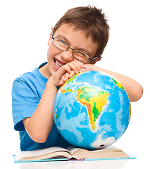 Image showing Little boy is examining globe