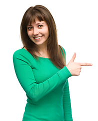 Image showing Portrait of a young woman pointing to the right