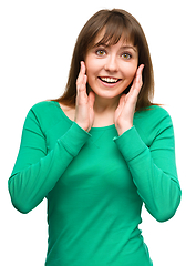 Image showing Woman is holding her face in astonishment