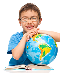 Image showing Little boy is examining globe