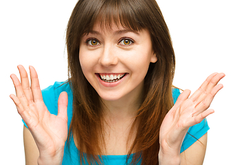 Image showing Portrait of a young woman raised her hands up