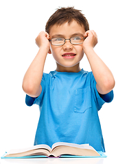 Image showing Little boy is reading a book