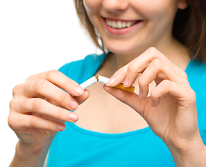 Image showing Young woman is breaking a cigarette