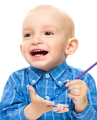 Image showing Little boy is playing with paints