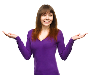 Image showing Portrait of a young woman raised her hands up