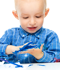 Image showing Little boy is playing with paints