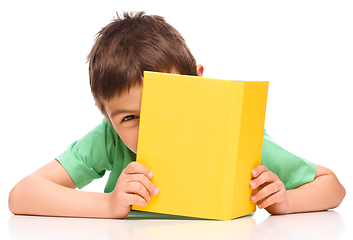 Image showing Little boy plays with book